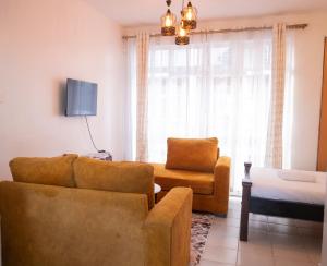 a living room with a couch and a chair at Serene Getaway Studio Along Ngong road-Nairobi,Kenya in Nairobi