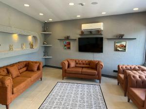 a waiting room with couches and a flat screen tv at Cim Pansiyon Konaklama in Antalya