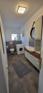 a bathroom with a sink and a washing machine at Ferienwohnung Schönborn in Schönborn