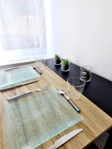 ein Holztisch mit Glaswaren darauf in der Unterkunft Studio 1 Cozy en centre-ville - Puy duFou in Les Herbiers