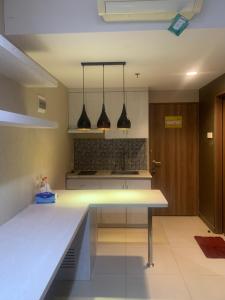 a kitchen with three lights hanging from the ceiling at Student park Apartment by ATA in Yogyakarta