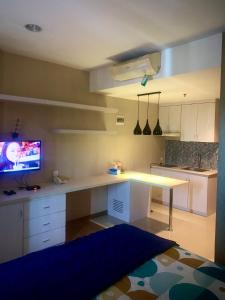 a kitchen with a desk and a tv in it at Student park Apartment by ATA in Seturan