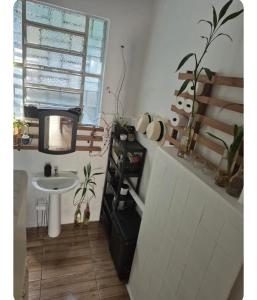 Un baño con lavabo y televisor. en Quarto 1 na Glória, en Río de Janeiro