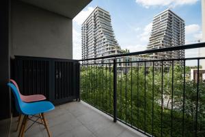 a balcony with a blue chair and two tall buildings at BW Vista in Belgrade