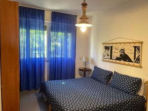 sypialnia z łóżkiem i niebieskimi zasłonami w obiekcie Milano Canal Apartments w Mediolanie
