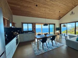 a kitchen and living room with a table and chairs at Casa Oceano Pico in Lajes do Pico