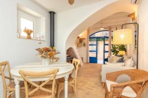 ein Esszimmer mit einem weißen Tisch und Stühlen in der Unterkunft Casa con encanto a pie de playa in Tamariu