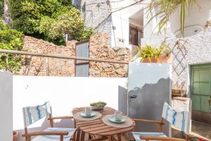 eine Terrasse mit einem Holztisch und Stühlen in der Unterkunft Casa con encanto a pie de playa in Tamariu