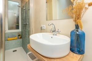 ein Badezimmer mit einem weißen Waschbecken und einer blauen Vase in der Unterkunft Casa con encanto a pie de playa in Tamariu + 21 Fotos
