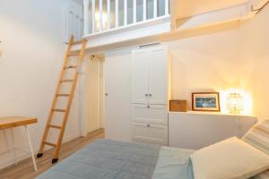 ein Schlafzimmer mit einem Etagenbett und einer Leiter in der Unterkunft Casa con encanto a pie de playa in Tamariu