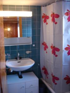 a bathroom with a sink and a shower curtain with flowers at Chalet Edith Oberems in Oberems
