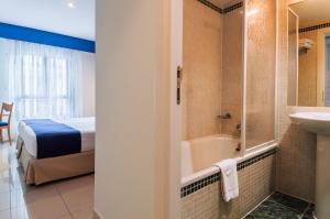 a bathroom with a tub and a bedroom with a bed at Villa De Pinto in Pinto