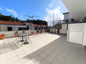 a patio with a table on top of a building at Villa Supranee Paradise in Câmara de Lobos