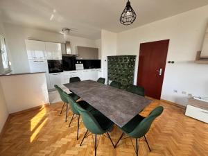 a dining room with a table and green chairs at Guest house with pool Ante in Vrsi
