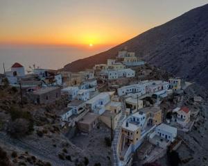 a group of buildings on a hill at sunset at Aeriko House Olympos Karpathos in Olympos
