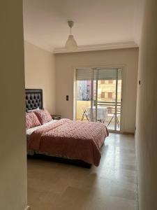 Un dormitorio con una cama grande y un balcón. en Modern Apartment in Casablanca & beach Access, en Casablanca