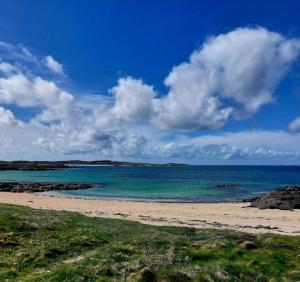 a beach with the ocean and clouds in the sky at Kings in Ballyconneely