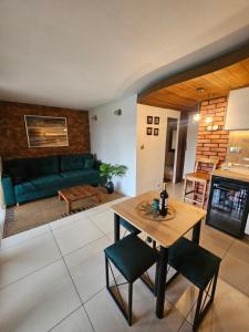 a living room with a green couch and a table at Domek Przy Promenadzie Zdrojowej in Gołdap