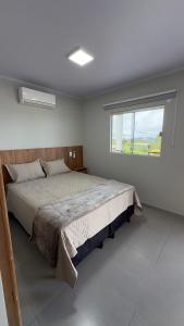 a bedroom with a large bed with a window at Lofts Clariô in Alto Paraíso de Goiás