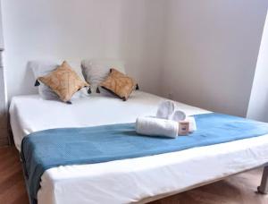 a bed with a blue blanket and pillows on it at Lumière dorée- Studio élégant-central in Hyères