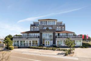 un edificio grande con muchas ventanas en Appartement Aalscholver - Residence Kabbelaarsbank (4 P) - not for companies, en Ouddorp