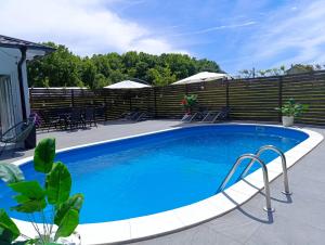a swimming pool with blue water in a backyard at Vikendica Konstantin Slatina-Banja Luka in Laktaši