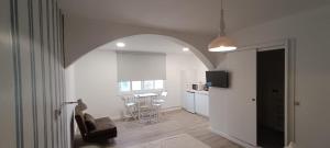 a living room with a chair and a kitchen with a table at Hostal Terraza Miramar SL in Boiro