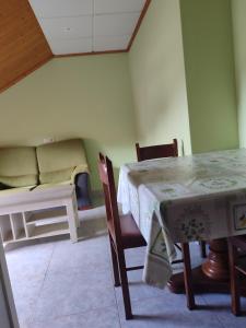 a room with a table and chairs and a couch at O vilar apartamentos n6 in Villalonga