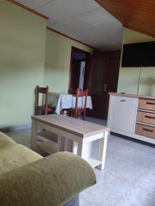 a living room with a table and chairs and a tv at O vilar apartamentos n6 in Villalonga