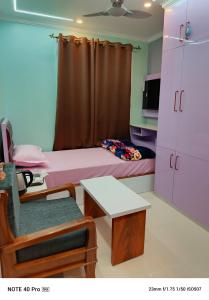 a room with a bed and a table and a chair at Chitta Jyoti Home Stay in Silchar