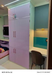 a bedroom with a desk and a pink closet at Chitta Jyoti Home Stay in Silchar