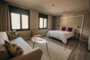 a hotel room with a bed and a couch at El Niu de Martinet in Martinet