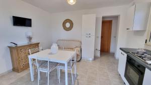 a kitchen with a white table and chairs in a room at Residence Maresol in Vieste