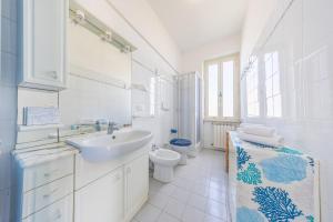 Un baño blanco con lavabo e inodoro. en La casa di Anna, en Nettuno 9 fotos más