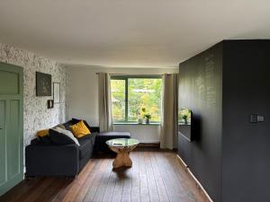 a living room with a couch and a table at Huisje de Haeg in Ermelo