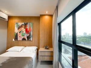 a bedroom with two beds and a large window at Studio Vista Dourada in Campo Grande
