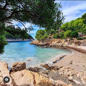 a view of a beach with blue water and rocks at Entre plages et centre-Ville in La Ciotat