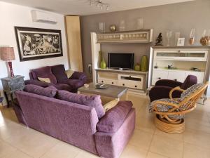 a living room with a purple couch and a tv at Casa Krystyna La Azohia in Cartagena