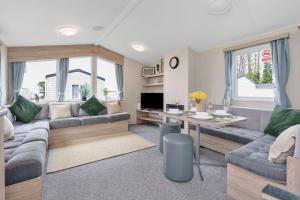 ein Wohnzimmer mit Sofa und Tisch in der Unterkunft Vacant Nests Seton Sands The Aberlady in Port Seton