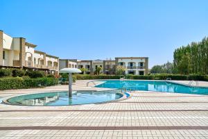 einen Pool mit Sonnenschirm im Innenhof in der Unterkunft Caorle Oasis Beach House - Host Solution in Caorle