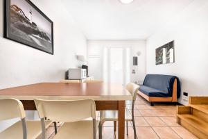 ein Esszimmer mit Tisch und Stühlen und einer Couch in der Unterkunft Caorle Oasis Beach House - Host Solution in Caorle