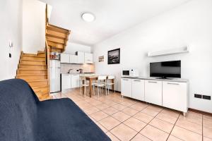 eine Küche und ein Wohnzimmer mit weißen Schränken und einem Tisch in der Unterkunft Caorle Oasis Beach House - Host Solution in Caorle
