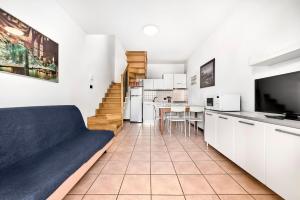 ein Wohnzimmer mit Couch und Küche in der Unterkunft Caorle Oasis Beach House - Host Solution in Caorle