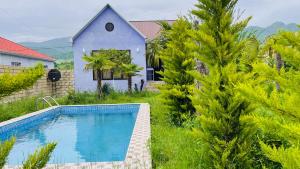 a villa with a swimming pool in front of a house at AkbA-Frame3 in İsmayıllı