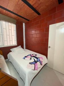 a bed in a room with a brick wall at Apartamento Carmen de Ápicala in Carmen de Apicalá