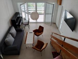 a living room with a couch and chairs and a piano at Beautiful Holiday House in Murter