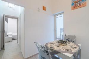 Un comedor blanco con una mesa y sillas. en Dafne home, en Siracusa