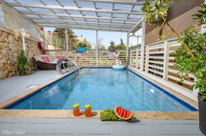 a swimming pool with watermelons on the edge of it at שקד באופק - וילה מקסימה עם 2 בריכות וג'קוזי מול החרמון in Metulla