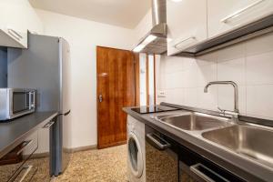 a kitchen with a sink and a refrigerator at Torre dell'orologio Apartment by Bricola Apartments in Venice +24 photos