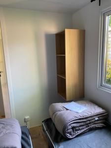 a room with two beds and a cabinet and a window at Camping Bois et Toilés in Peyraud